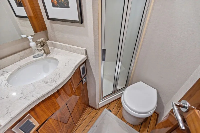 Slide: The Image of Luxurious bathroom in 2021 Viking 52 Sport Tower yacht with modern fixtures and wood accents. - 61