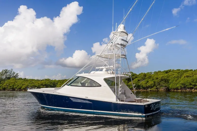 Slide: The Image of 2021 Viking 52 Sport Tower yacht cruising on calm waters under a blue sky. - 12