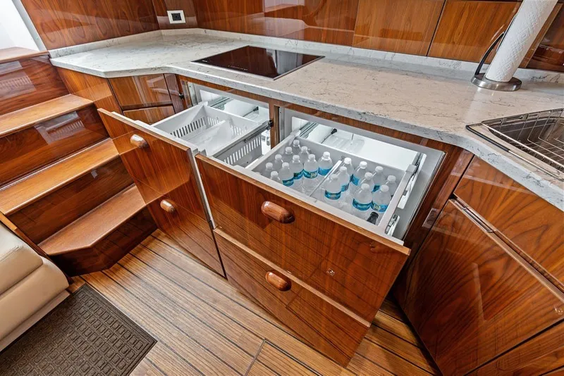 Slide: The Image of Luxurious 2021 Viking 52 Sport Tower yacht kitchen with wooden cabinetry and built-in refrigerator drawers. - 50