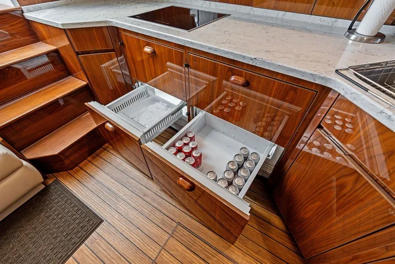Slide: The Image of Luxurious 2021 Viking 52 Sport Tower yacht kitchen with open drawers and sleek wood finish. - 51