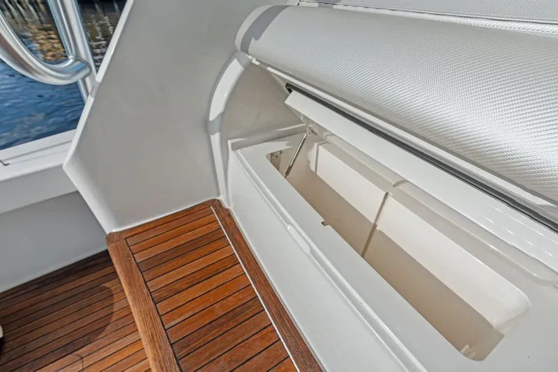 Slide: The Image of 2021 Viking 52 Sport Tower interior with wooden flooring and storage compartment. - 33