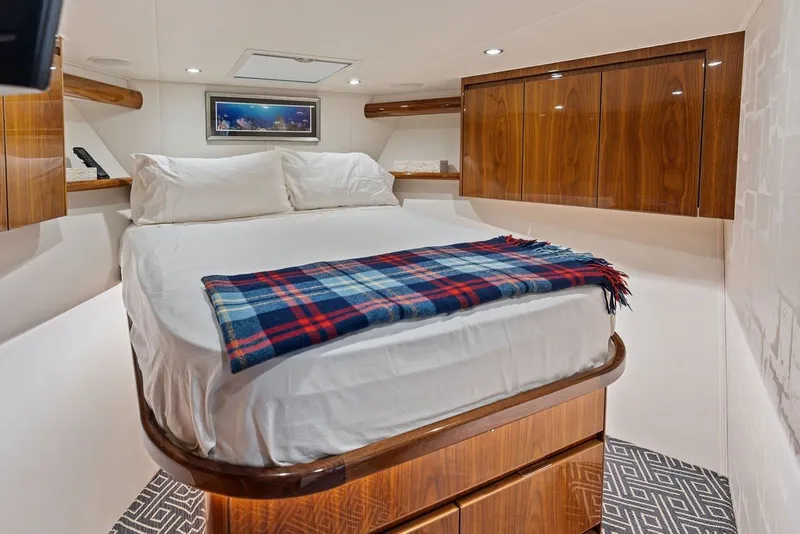Slide: The Image of Luxurious cabin interior of 2021 Viking 52 Sport Tower with cozy bed and plaid blanket. - 55