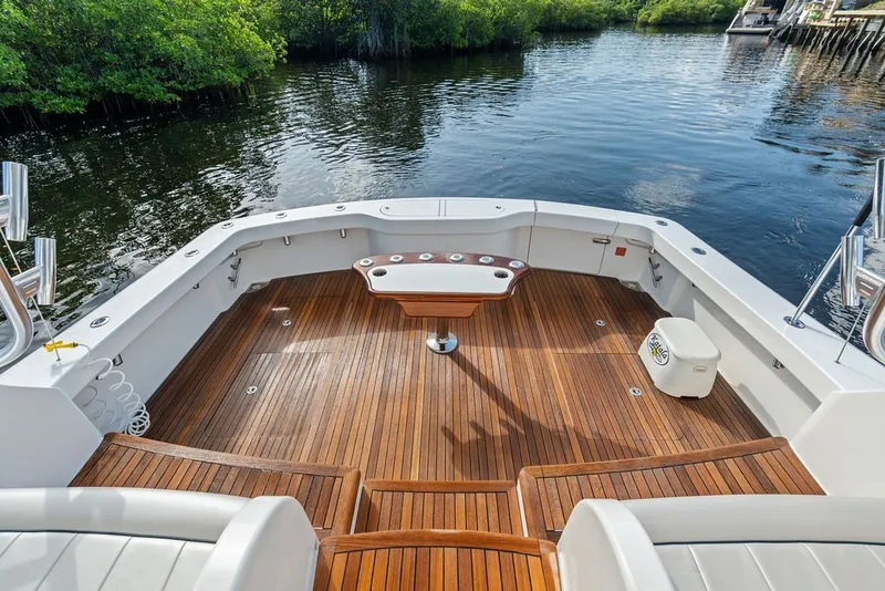 Slide: The Image of 2021 Viking 52 Sport Tower boat with teak deck, docked by lush greenery. - 26