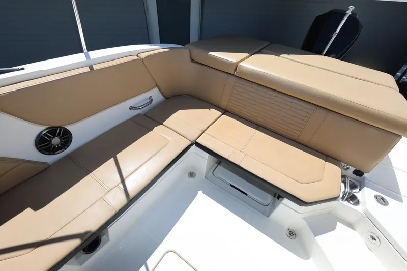 Slide: The Image of 2023 Sea Ray SPX 230 Outboard boat interior with tan seating and speaker. - 11