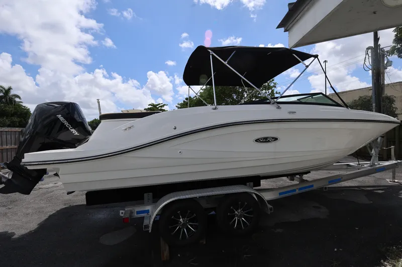 Slide: The Image of 2023 Sea Ray SPX 230 Outboard boat on trailer under blue sky. - 6