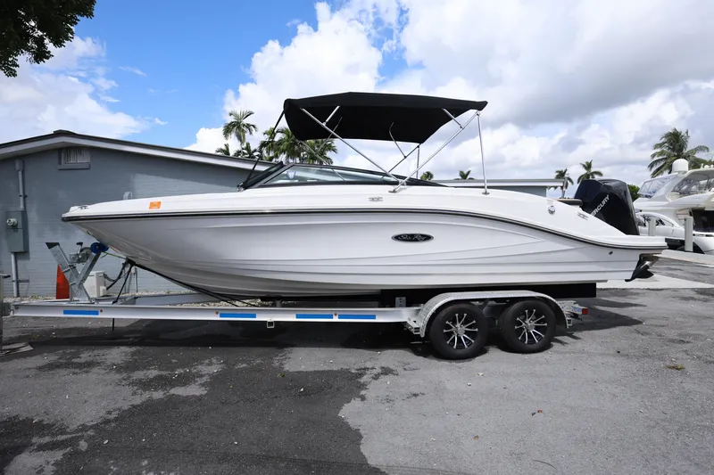 The Image of 2023 Sea Ray SPX 230 Outboard boat on trailer, parked outdoors under cloudy sky. - 0