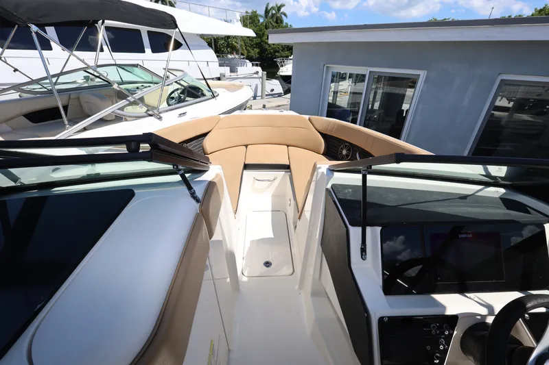 Slide: The Image of 2023 Sea Ray SPX 230 Outboard boat interior with tan seating and modern dashboard. - 15