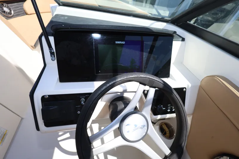 Slide: The Image of 2023 Sea Ray SPX 230 Outboard dashboard with steering wheel and navigation display. - 14