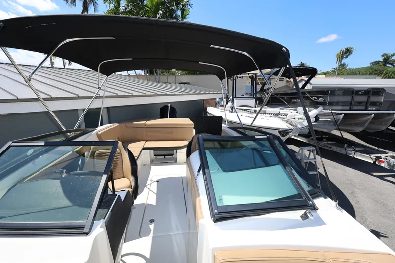 Slide: The Image of 2023 Sea Ray SPX 230 Outboard boat with tan seating and black canopy. - 18