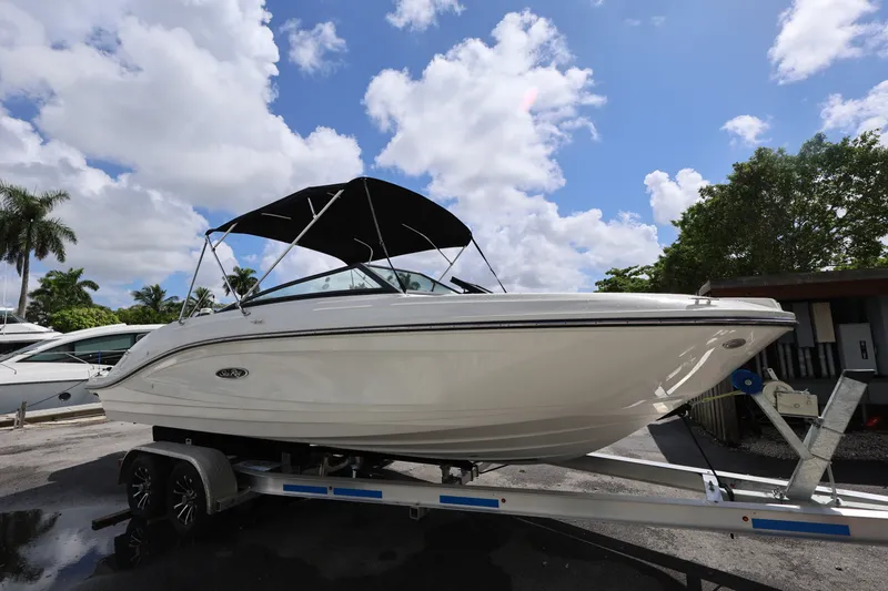 Slide: The Image of 2023 Sea Ray SPX 230 Outboard boat on trailer under blue sky. - 7