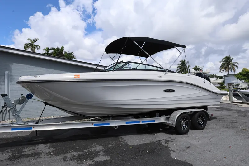 Slide: The Image of 2023 Sea Ray SPX 230 Outboard boat on trailer, parked outdoors under cloudy sky. - 1