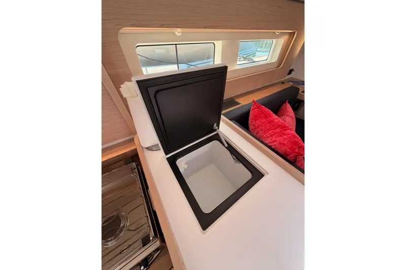 Slide: The Image of Interior of 2022 Beneteau Oceanis Yacht 54, featuring a sleek kitchen area with open storage. - 49
