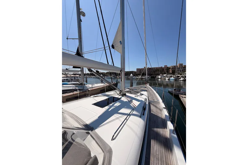 Slide: The Image of 2022 Beneteau Oceanis Yacht 54 docked in a marina under clear blue skies. - 18