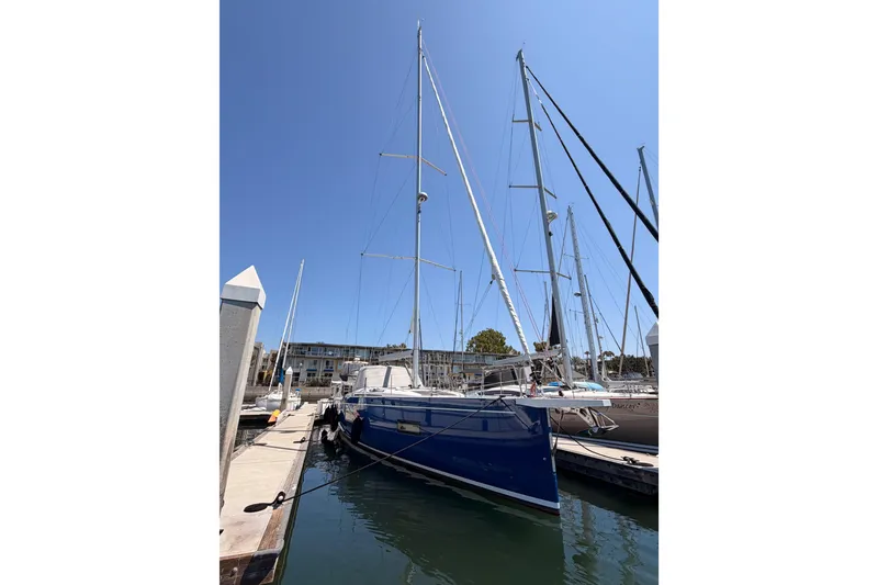 Slide: The Image of 2022 Beneteau Oceanis Yacht 54 docked at marina under clear blue sky. - 94