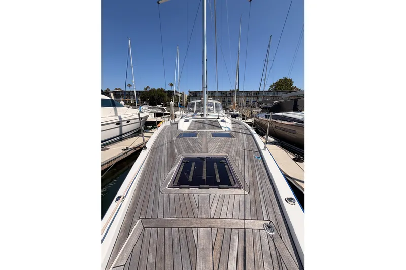 Slide: The Image of 2022 Beneteau Oceanis Yacht 54 docked, showcasing sleek wooden deck design. - 26