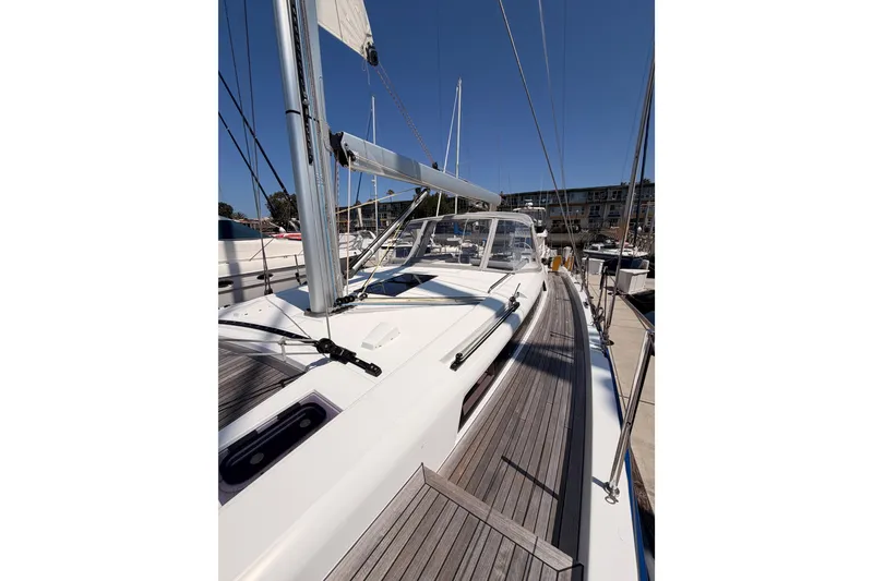 Slide: The Image of 2022 Beneteau Oceanis Yacht 54, sleek deck design, docked under clear blue sky. - 28