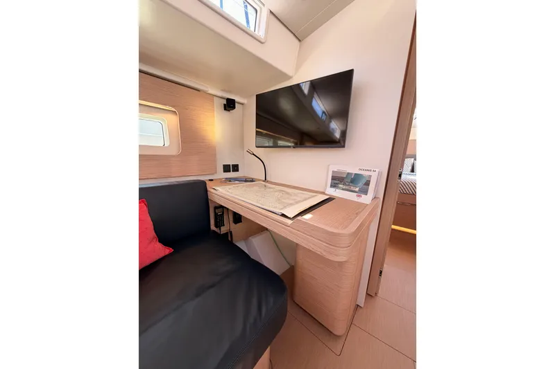 Slide: The Image of Interior of 2022 Beneteau Oceanis Yacht 54 with desk, TV, and seating area. - 75