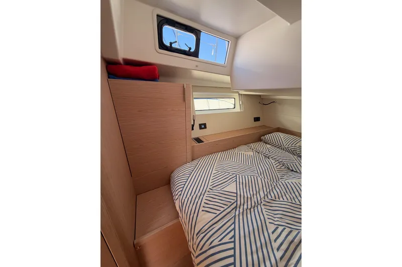 Slide: The Image of Cozy cabin interior of 2022 Beneteau Oceanis Yacht 54 with striped bedding and natural light. - 66