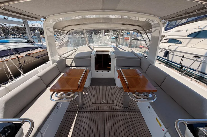Slide: The Image of Luxurious 2022 Beneteau Oceanis Yacht 54 cockpit with elegant seating and wooden tables. - 40