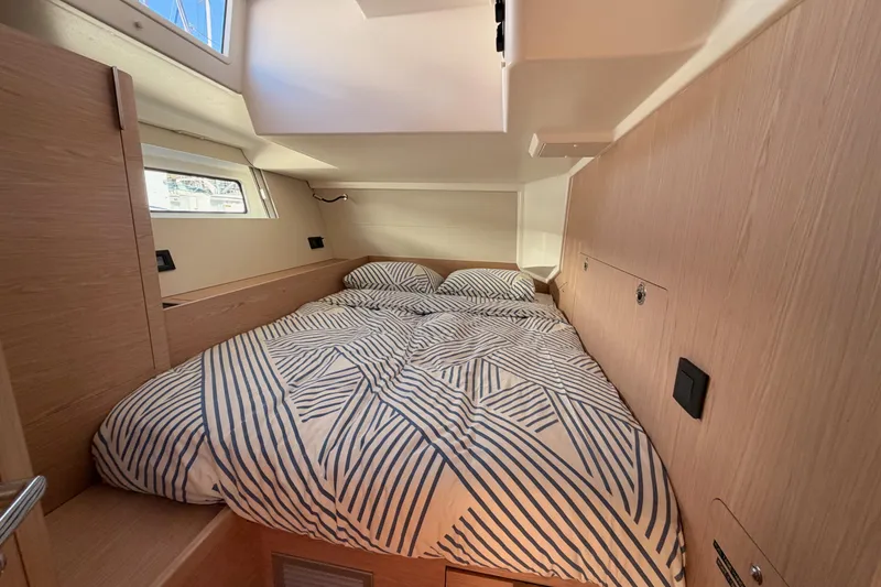 Slide: The Image of Cozy cabin interior of 2022 Beneteau Oceanis Yacht 54 with striped bedding. - 65