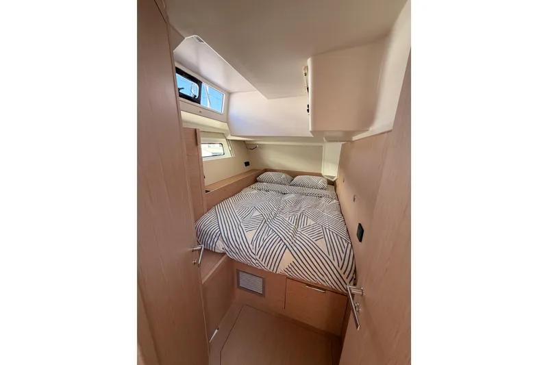 Slide: The Image of Cozy cabin interior of 2022 Beneteau Oceanis Yacht 54 with patterned bedding. - 64