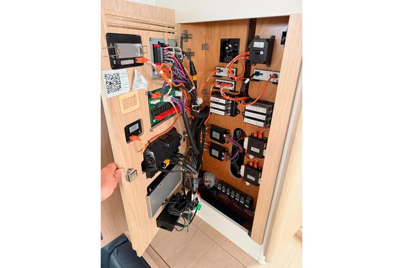 Slide: The Image of Electrical panel inside 2022 Beneteau Oceanis Yacht 54, showcasing wiring and components. - 93