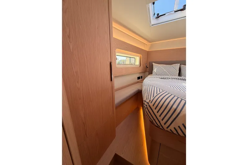 Slide: The Image of Luxurious cabin interior of 2022 Beneteau Oceanis Yacht 54 with modern bedding and wood finishes. - 81