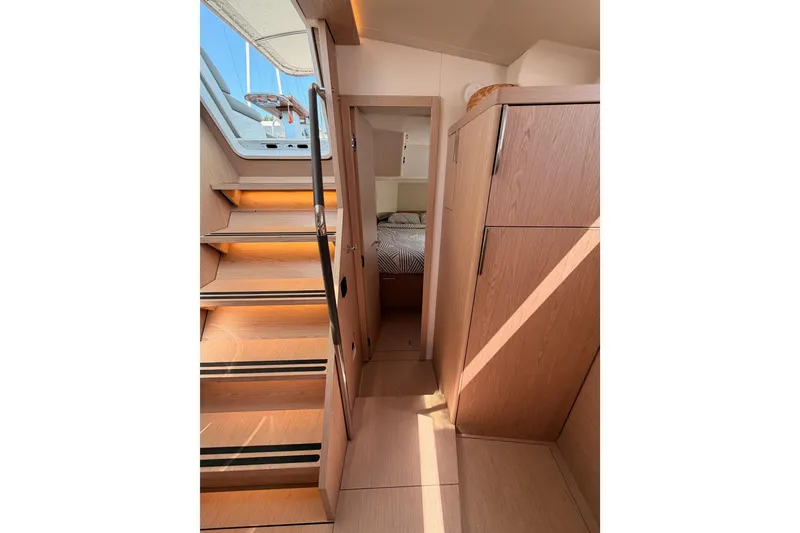 Slide: The Image of Interior of 2022 Beneteau Oceanis Yacht 54, featuring wooden stairs and cabin entrance. - 54