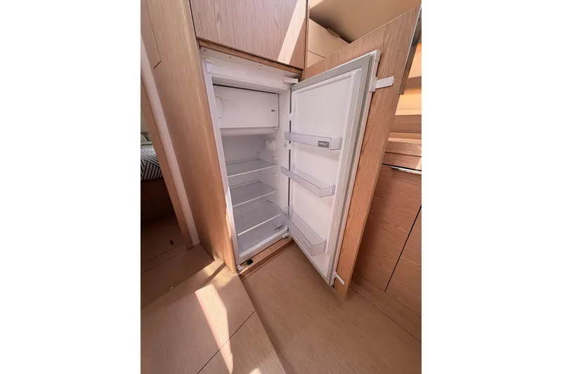 Slide: The Image of Open refrigerator inside 2022 Beneteau Oceanis Yacht 54, showcasing spacious interior design. - 53