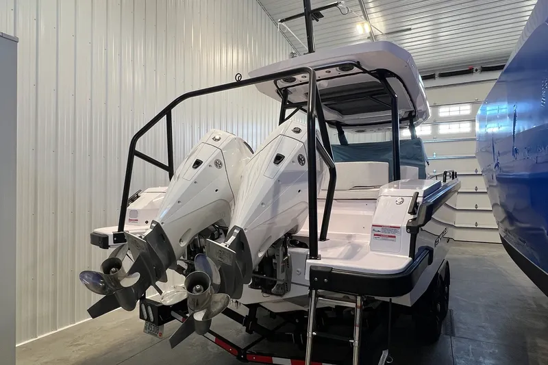 Slide: The Image of 2027 Axopar 29 Sun-Top boat with dual outboard motors in a garage setting. - 11