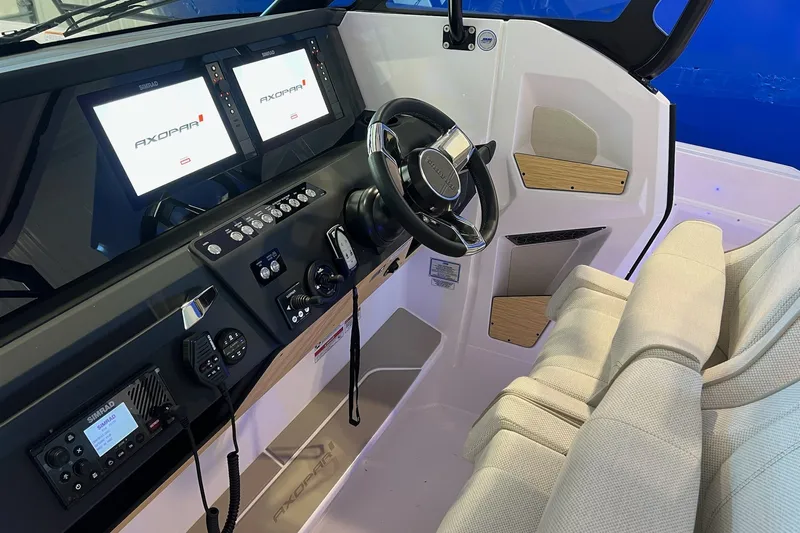 Slide: The Image of 2027 Axopar 29 Sun-Top boat interior with modern dashboard and dual displays. - 24