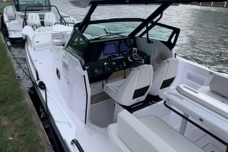 Slide: The Image of 2027 Axopar 29 Sun-Top boat docked, featuring sleek design and modern cockpit. - 4