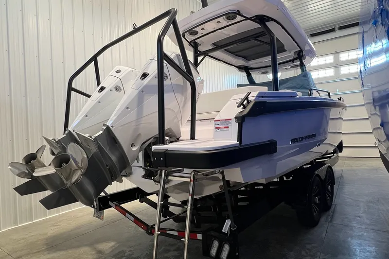 Slide: The Image of 2027 Axopar 29 Sun-Top boat in a garage, showcasing dual outboard engines. - 12