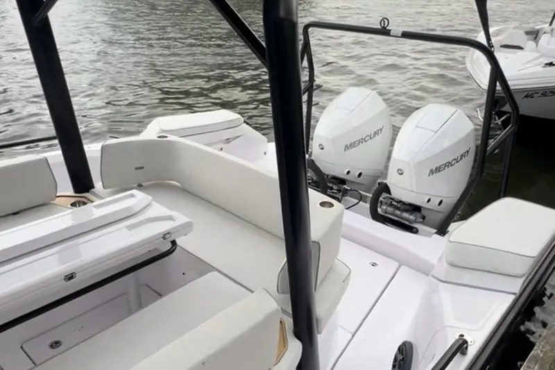 Slide: The Image of 2027 Axopar 29 Sun-Top boat with dual Mercury engines on a calm water surface. - 7