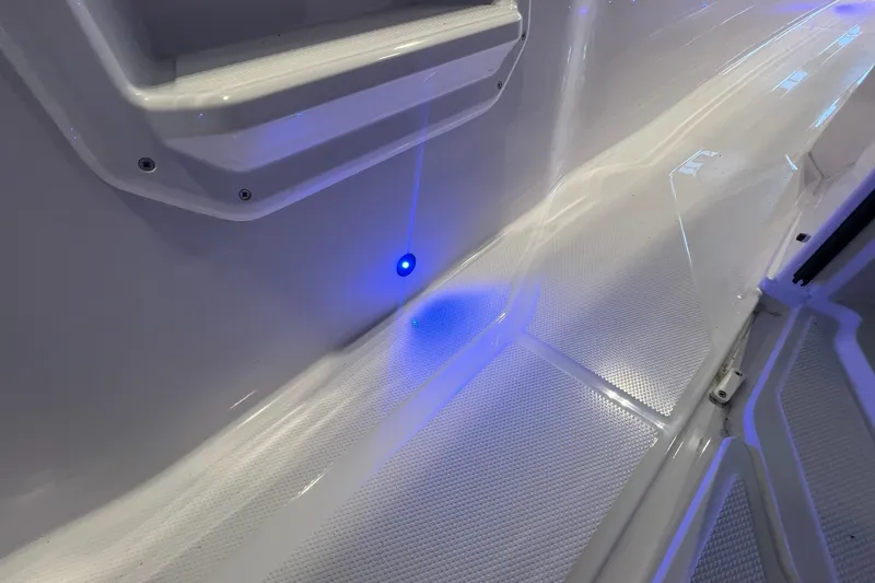 Slide: The Image of 2027 Axopar 29 Sun-Top boat interior with blue LED lighting and textured flooring. - 30