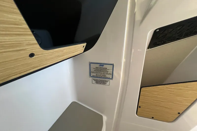 Slide: The Image of Interior detail of 2027 Axopar 29 Sun-Top boat with wood accents and certification plaque. - 31