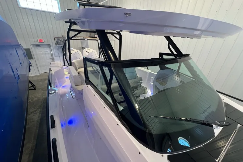 Slide: The Image of 2027 Axopar 29 Sun-Top boat in showroom, featuring sleek design and modern interior. - 28