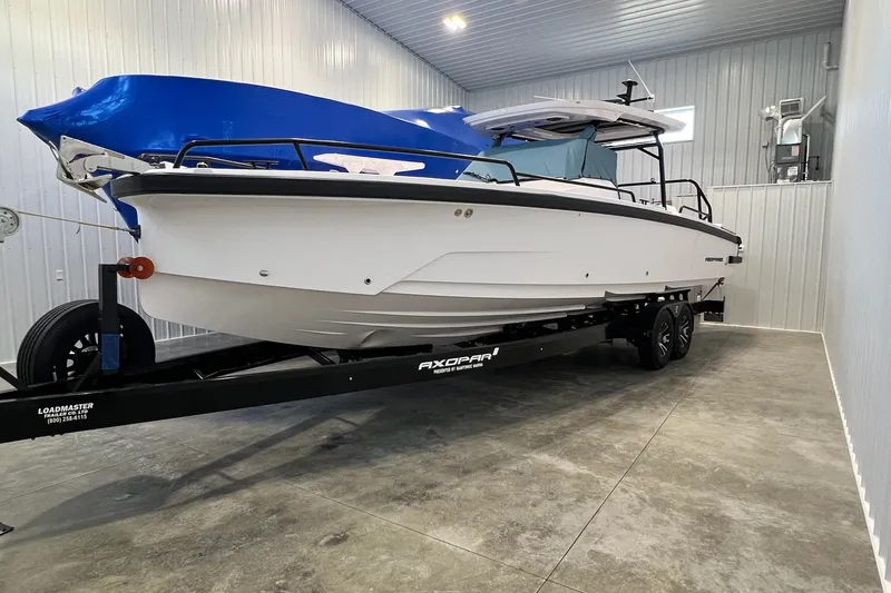 Slide: The Image of 2027 Axopar 29 Sun-Top boat on trailer in indoor storage facility. - 13