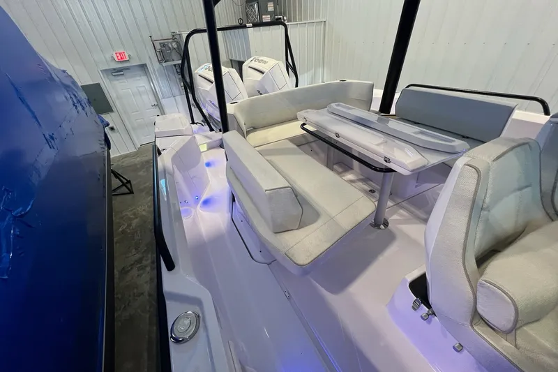 Slide: The Image of 2027 Axopar 29 Sun-Top boat interior with seating and table in a showroom. - 29