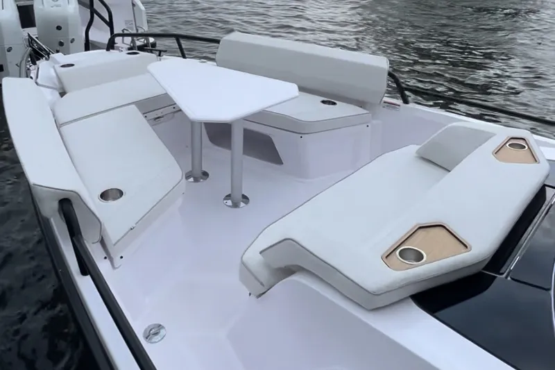 Slide: The Image of 2027 Axopar 29 Sun-Top boat interior with white seating and table on water. - 8