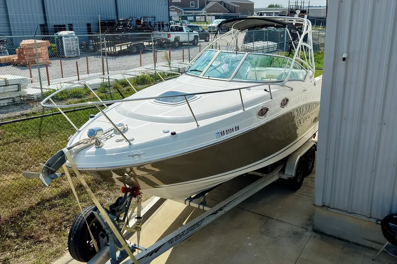 Slide: The Image of 2007 Sea Ray 270 Amberjack boat on trailer, parked near industrial buildings. - 31