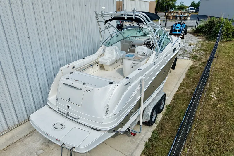 Slide: The Image of 2007 Sea Ray 270 Amberjack boat on trailer, parked near a metal building. - 3