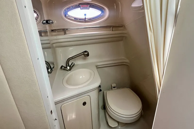 Slide: The Image of 2007 Sea Ray 270 Amberjack boat bathroom with sink, toilet, and porthole window. - 29