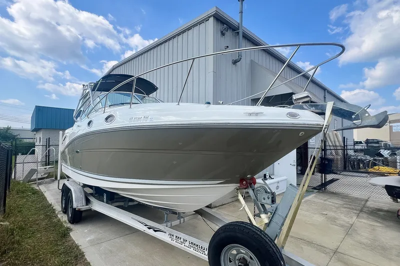 Slide: The Image of 2007 Sea Ray 270 Amberjack boat on trailer, parked outdoors near a building. - 34