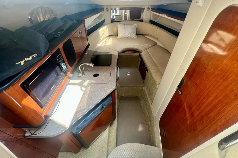 Slide: The Image of Interior of 2007 Sea Ray 270 Amberjack boat with kitchenette and seating area. - 23