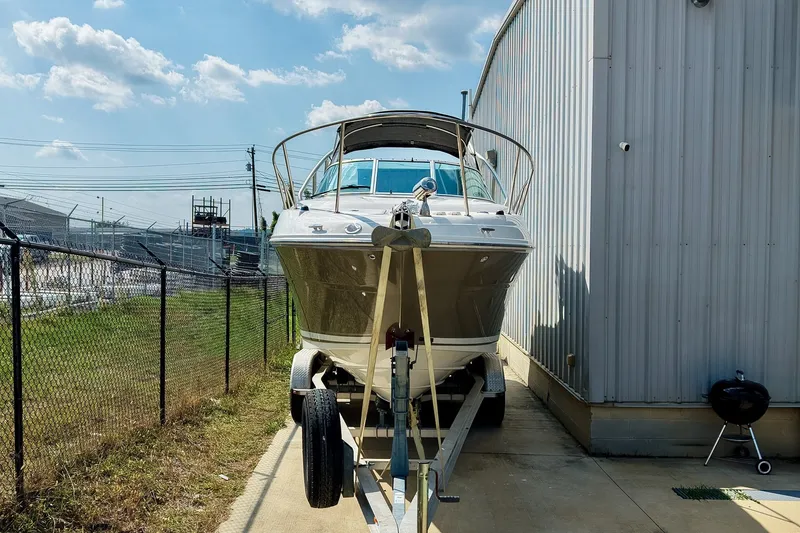Slide: The Image of 2007 Sea Ray 270 Amberjack boat on trailer beside a metal building under a clear sky. - 37