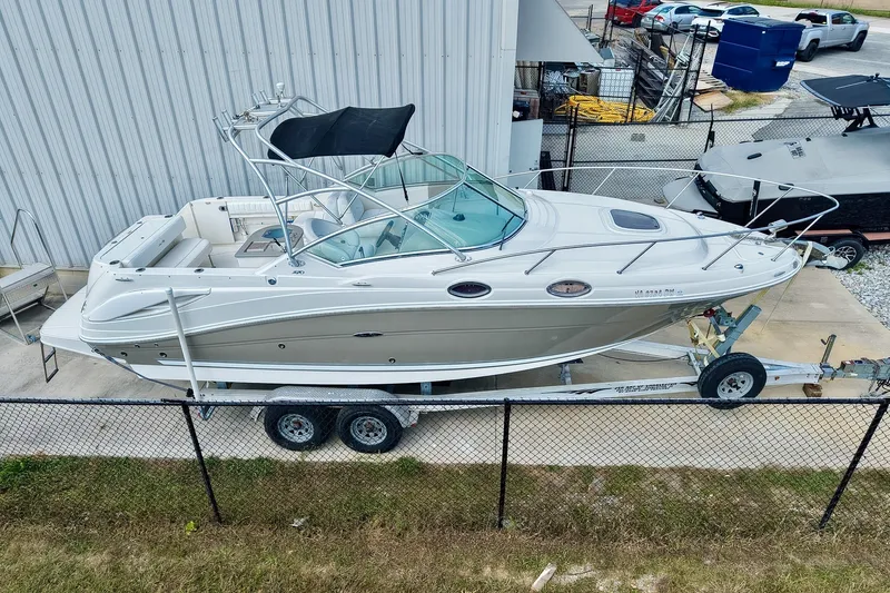 Slide: The Image of 2007 Sea Ray 270 Amberjack boat on trailer, parked near a metal building. - 40