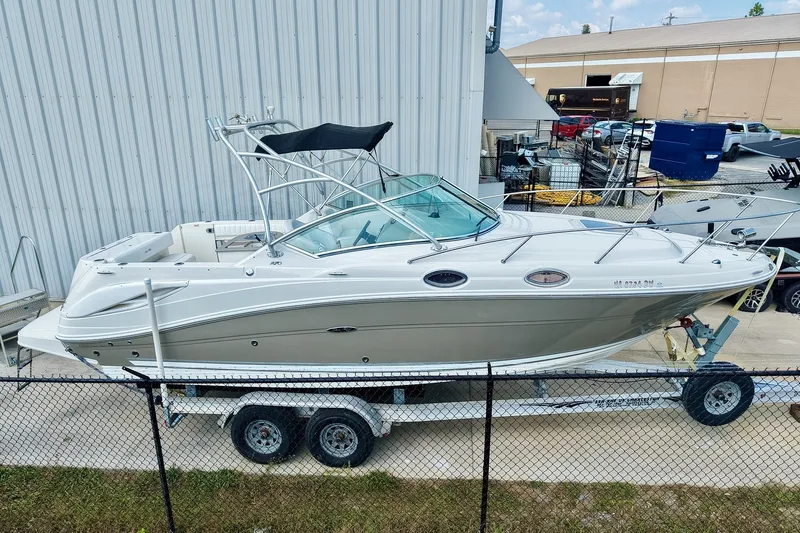 Slide: The Image of 2007 Sea Ray 270 Amberjack boat on trailer, parked near industrial building. - 1