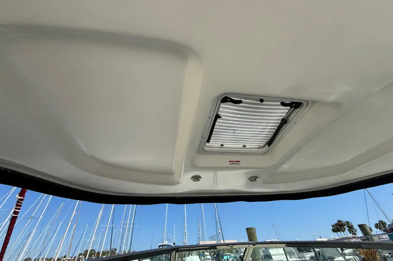 Slide: The Image of 2008 Sea Ray 38 Sundancer boat ceiling with hatch, marina view in background. - 99