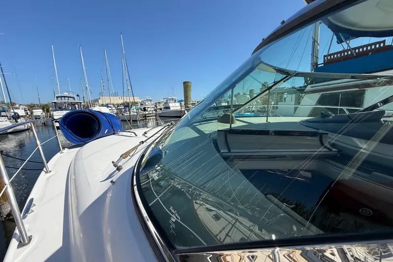 Slide: The Image of 2008 Sea Ray 38 Sundancer yacht docked at marina, showcasing sleek design and clear blue sky. - 24